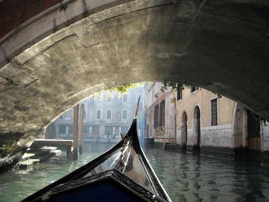 blue and white boat on river under gray concrete bridge during daytime in Venezia Santa Lucia Italy