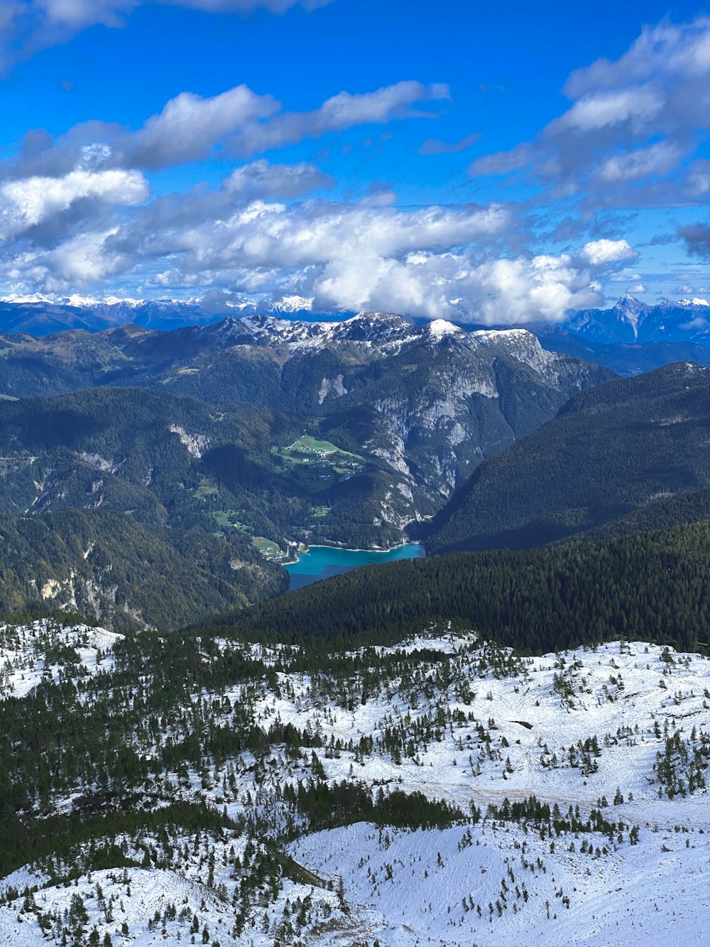 green trees on snow covered mountain under cloudy sky during daytime