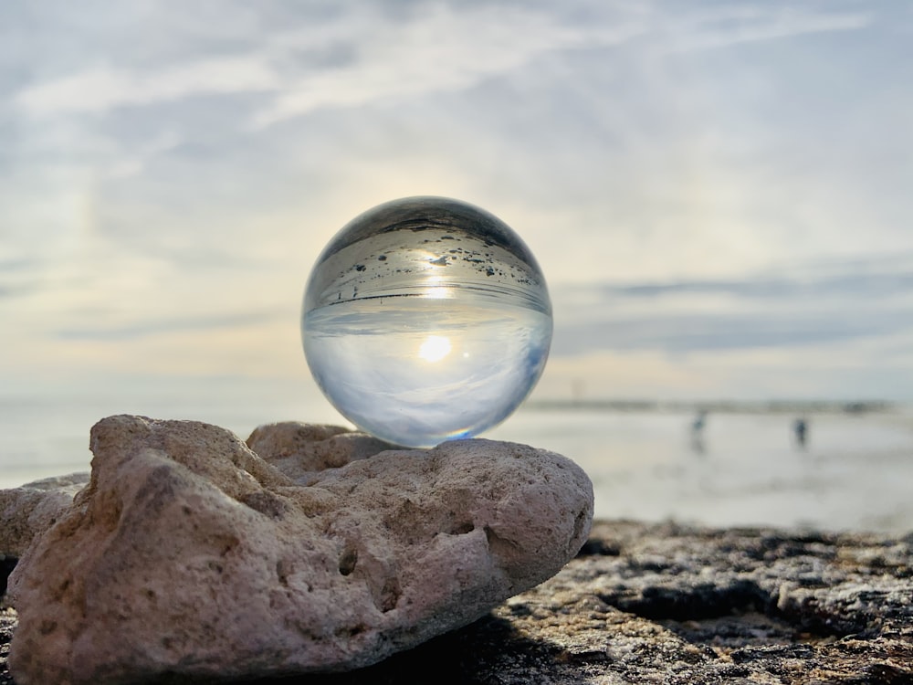 clear glass ball on brown rock