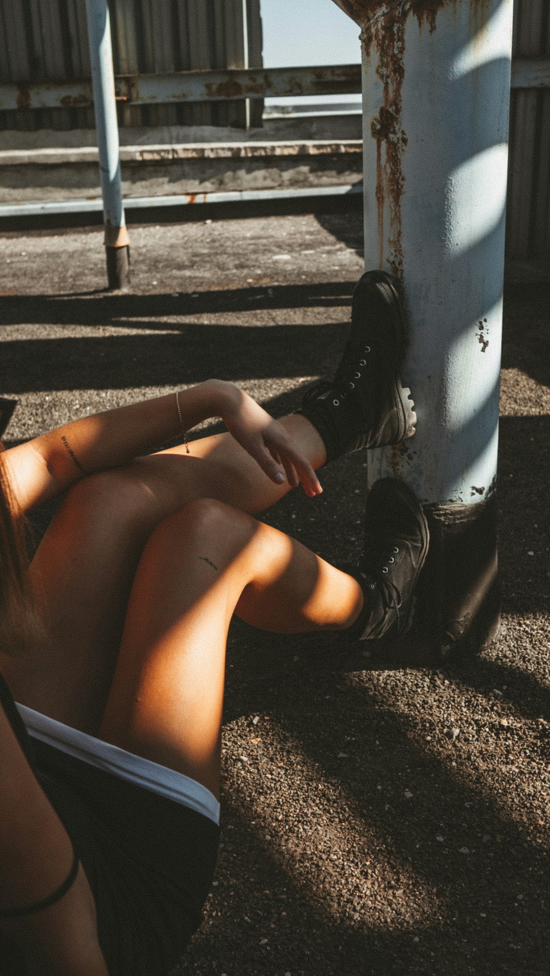 woman in black leather boots sitting on bench