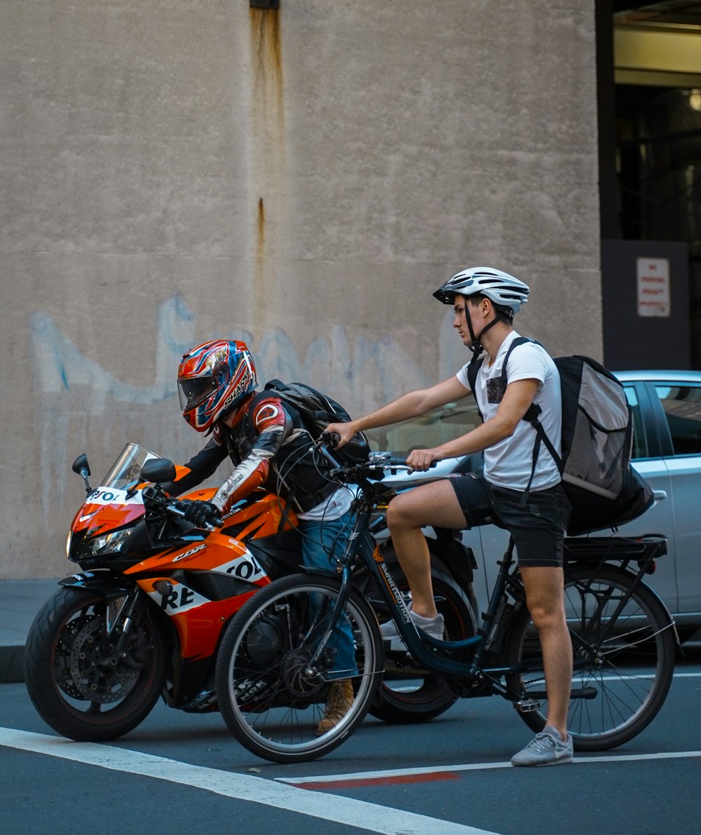 man in black and white shirt riding orange and black motorcycle