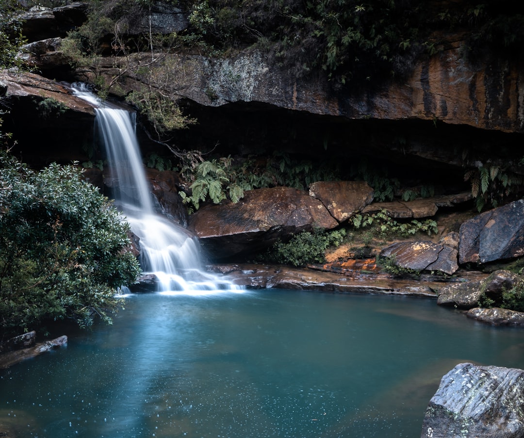 water falls in the middle of rocky mountain