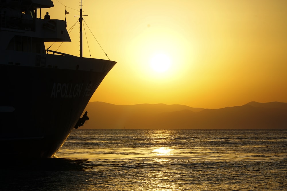 silhouette of ship on sea during sunset