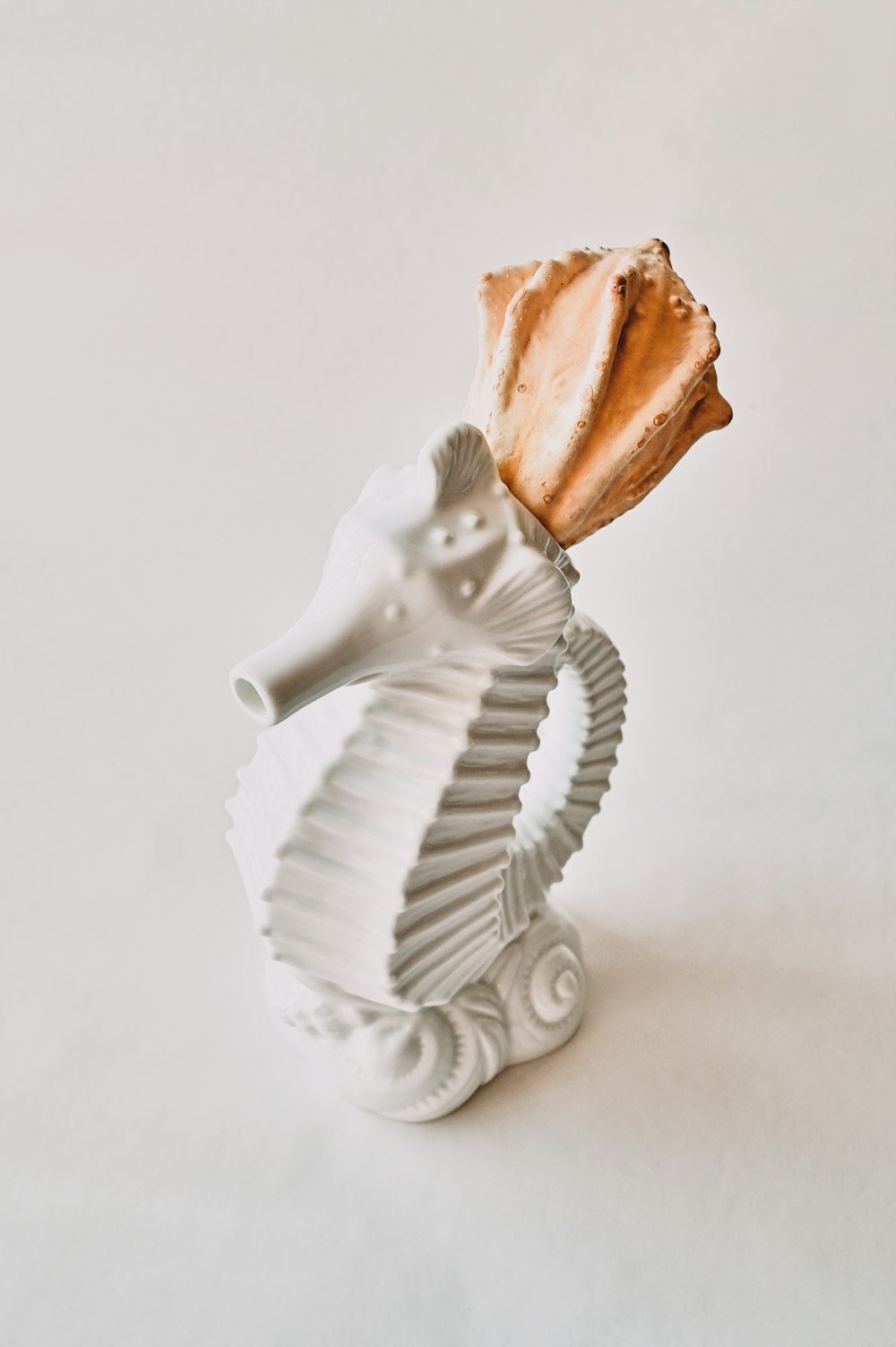 white ceramic angel figurine on white surface