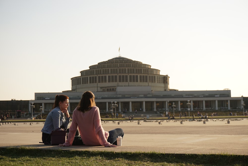 couple sitting on bench near building during daytime