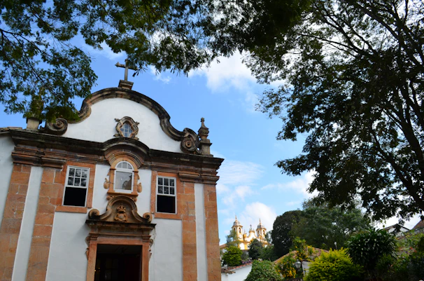 Historic Brazilian church facade with intricate colonial baroque details under a clear blue sky.