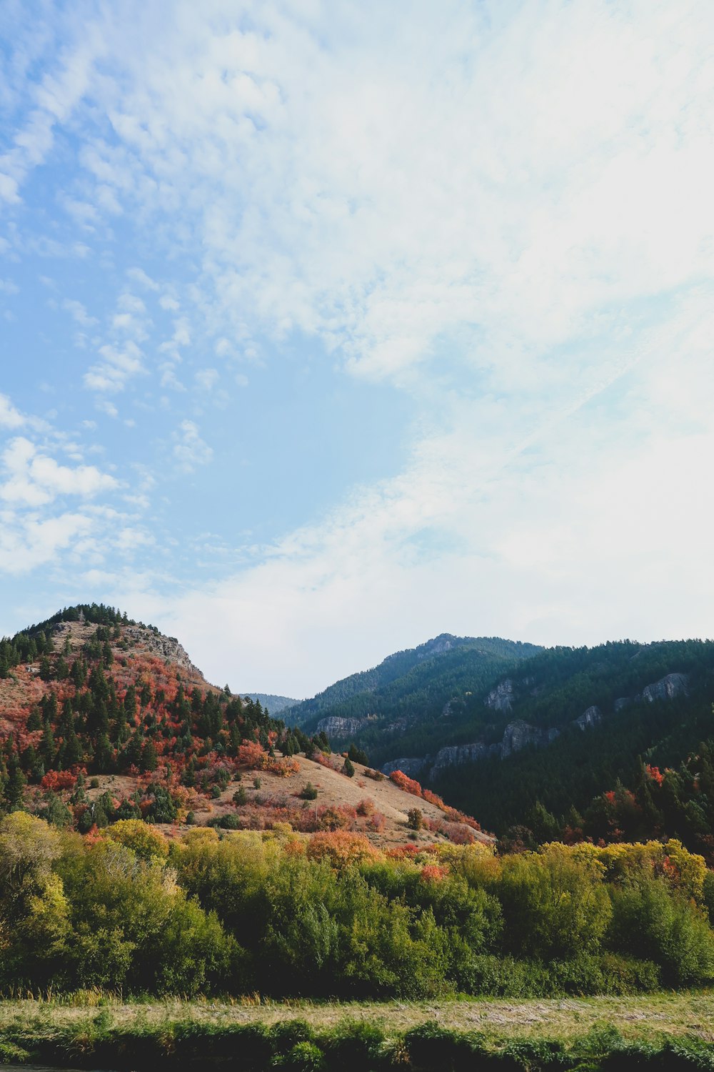 green and brown mountains under white clouds and blue sky during daytime