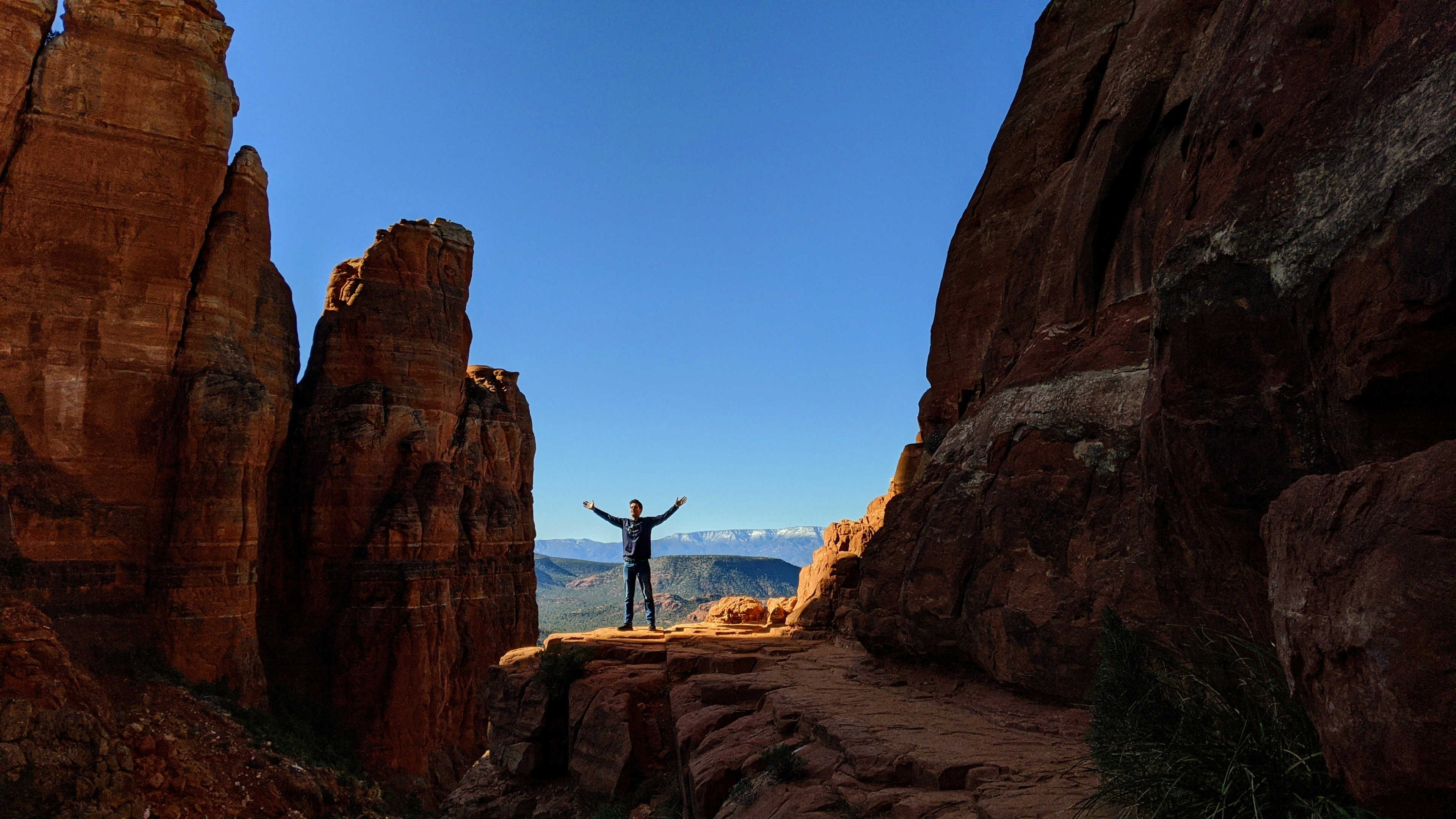 man standing on brown rock formation during daytime