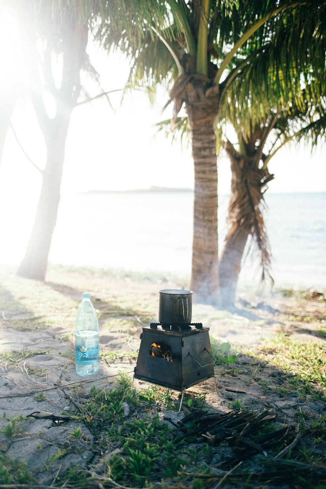 black box beside clear plastic bottle on gray sand during daytime