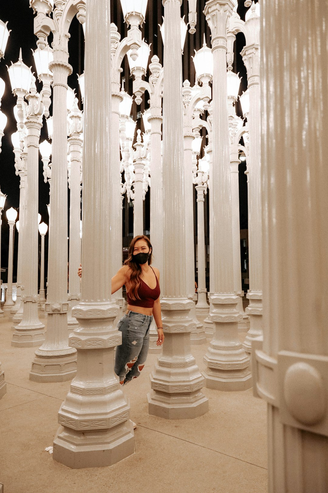 woman in orange shirt standing in front of white pillars