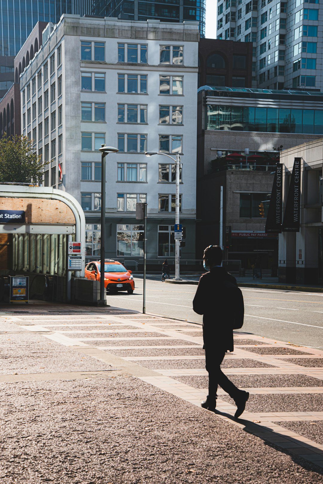 man in black jacket walking on sidewalk during daytime