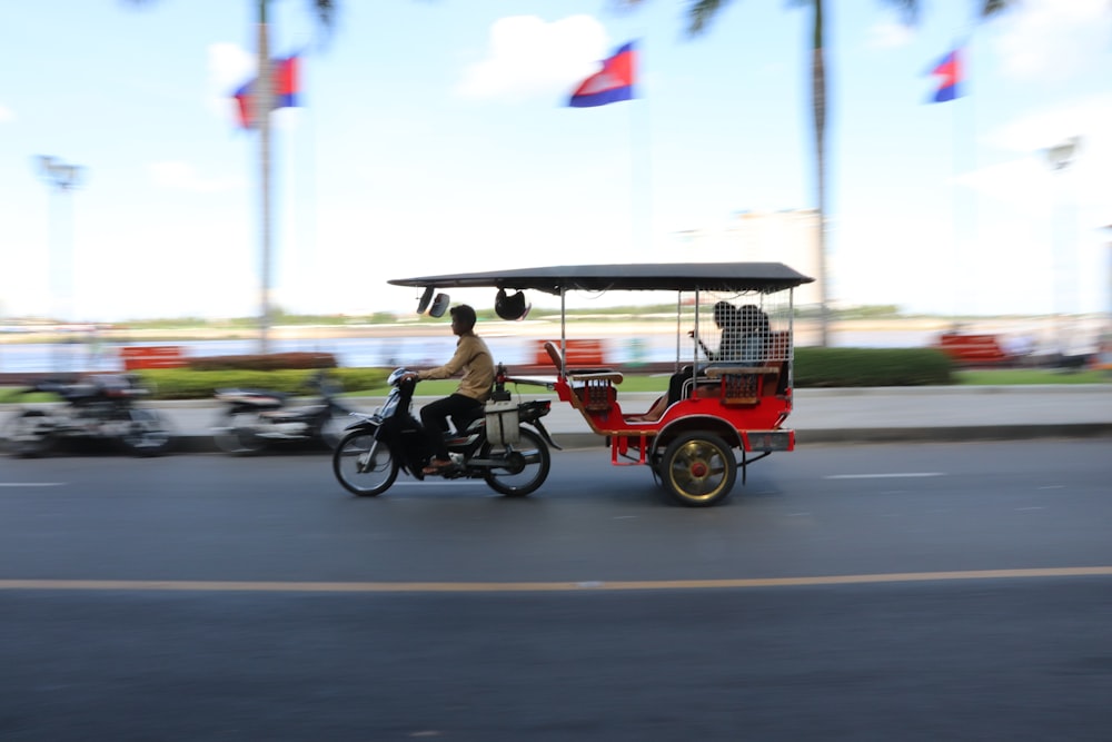 man in black jacket riding on red and black motorcycle during daytime