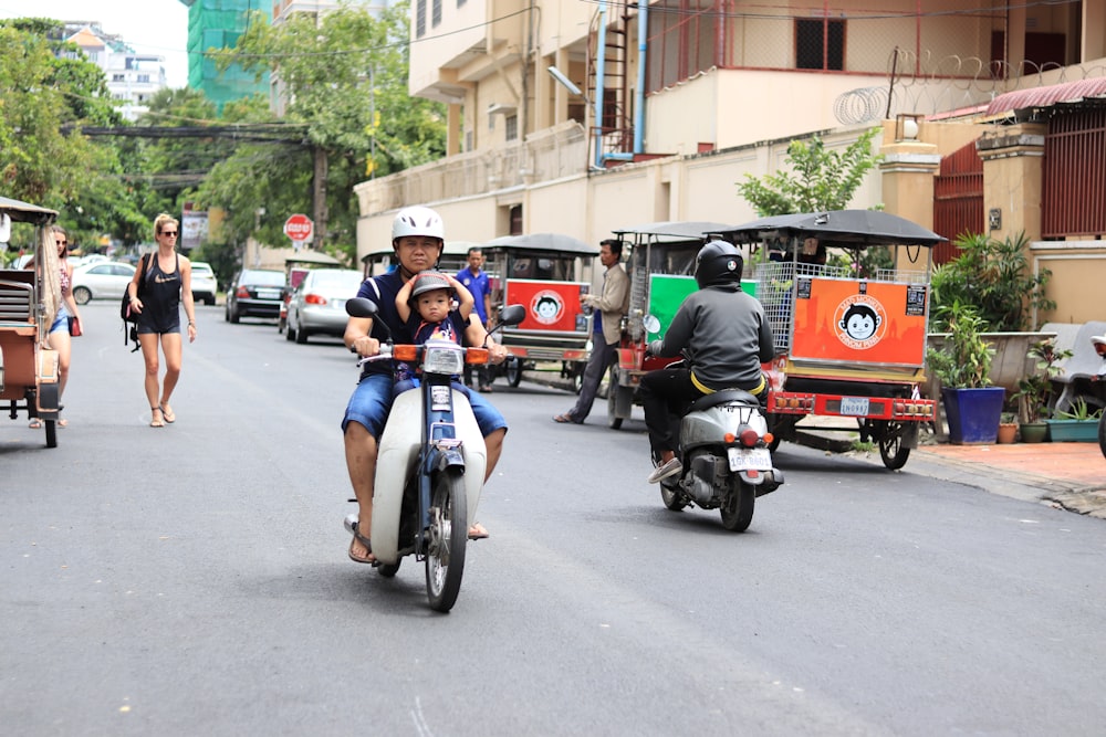 man in blue shirt riding on blue motorcycle during daytime