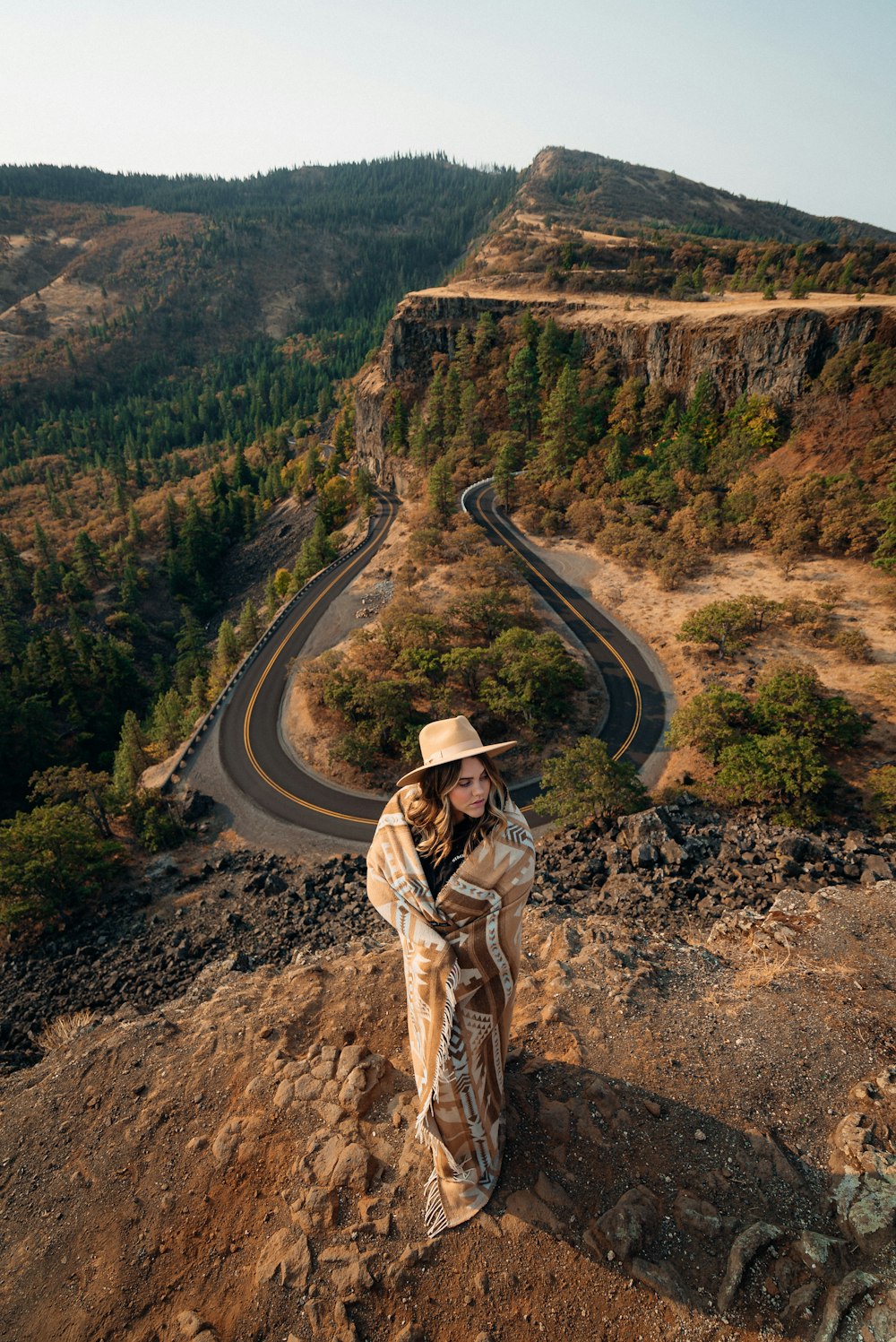 man in brown jacket and brown hat walking on dirt road during daytime