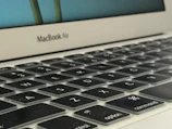 Top view of a MacBook keyboard with subtle shadows on a white surface.