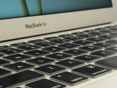 Top view of a MacBook keyboard with subtle shadows on a white surface.