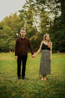 man and woman standing on green grass field during daytime