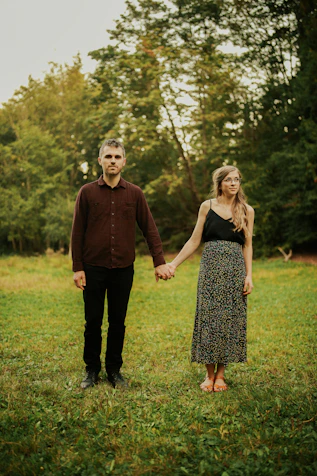 man and woman standing on green grass field during daytime
