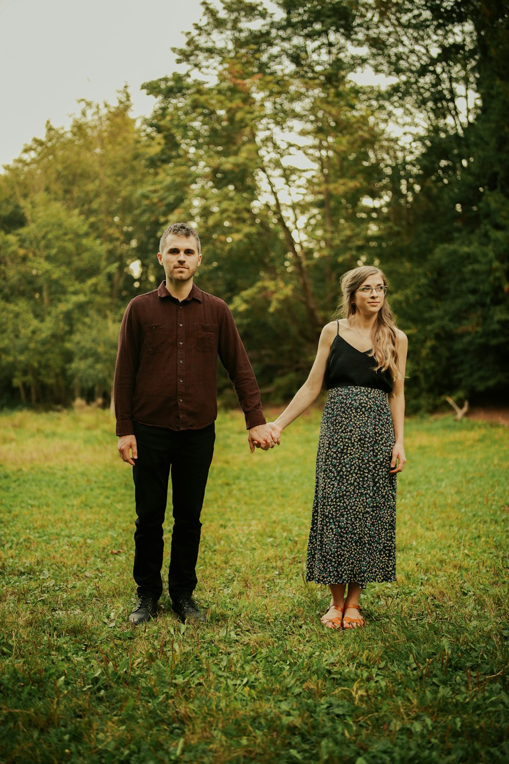 man and woman standing on green grass field during daytime