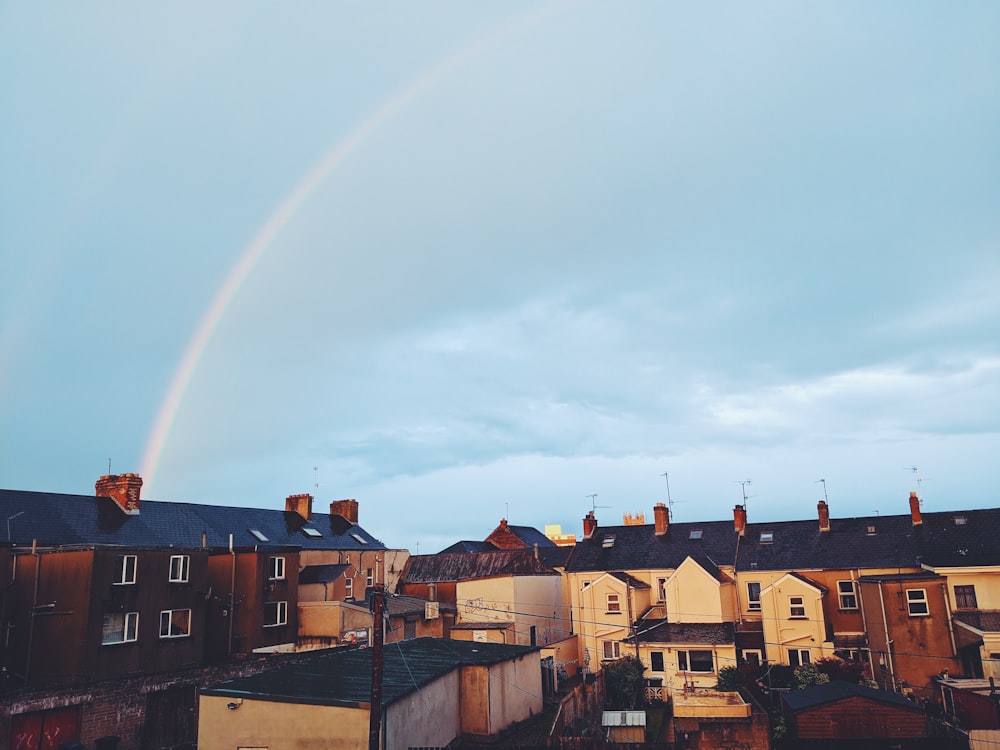 brown and white concrete buildings under rainbow