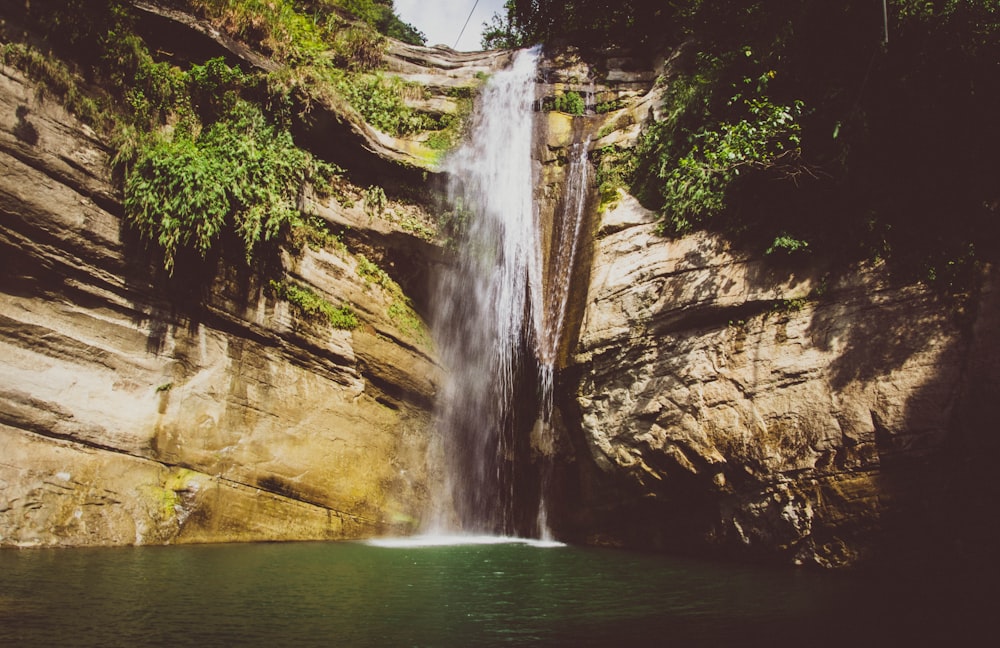 waterfalls on brown rocky mountain during daytime