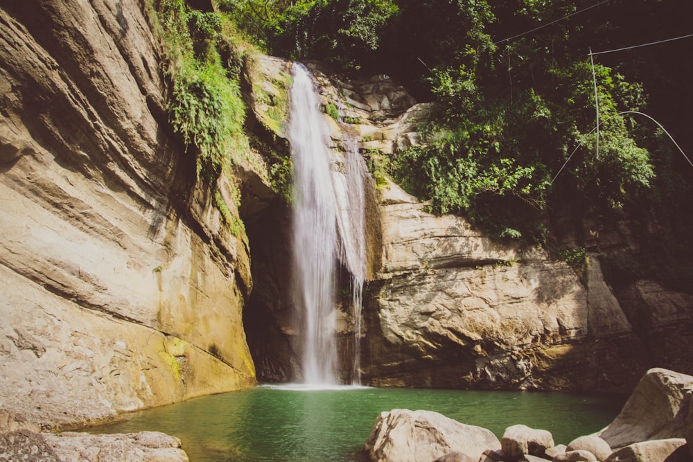 water falls on brown rocky mountain