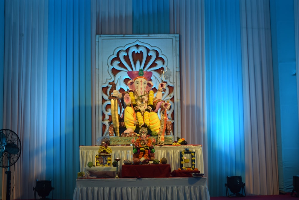 gold hindu deity figurine on white table