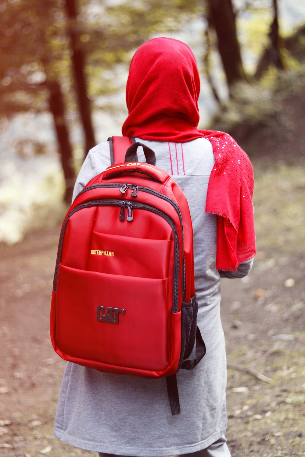 person in red and white hoodie carrying red backpack
