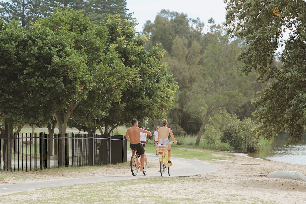 man in orange shirt riding bicycle on road during daytime