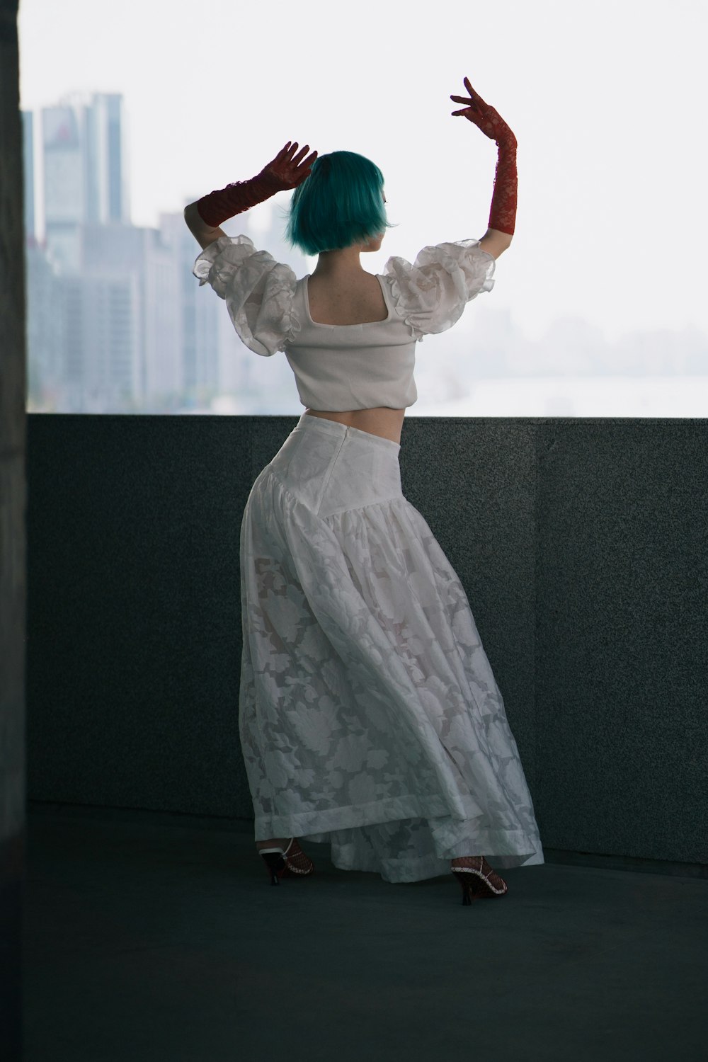 woman in white dress holding blue umbrella