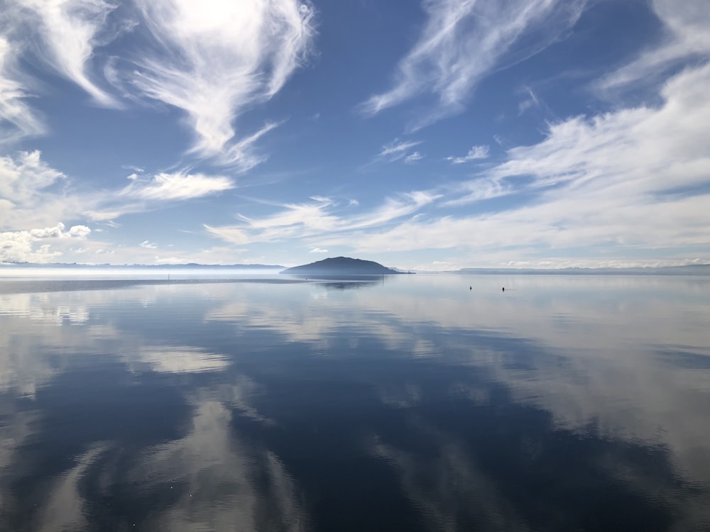 céu azul e nuvens brancas sobre o mar calmo