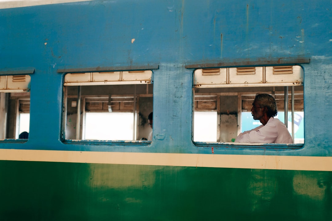 man in white shirt sitting on train seat