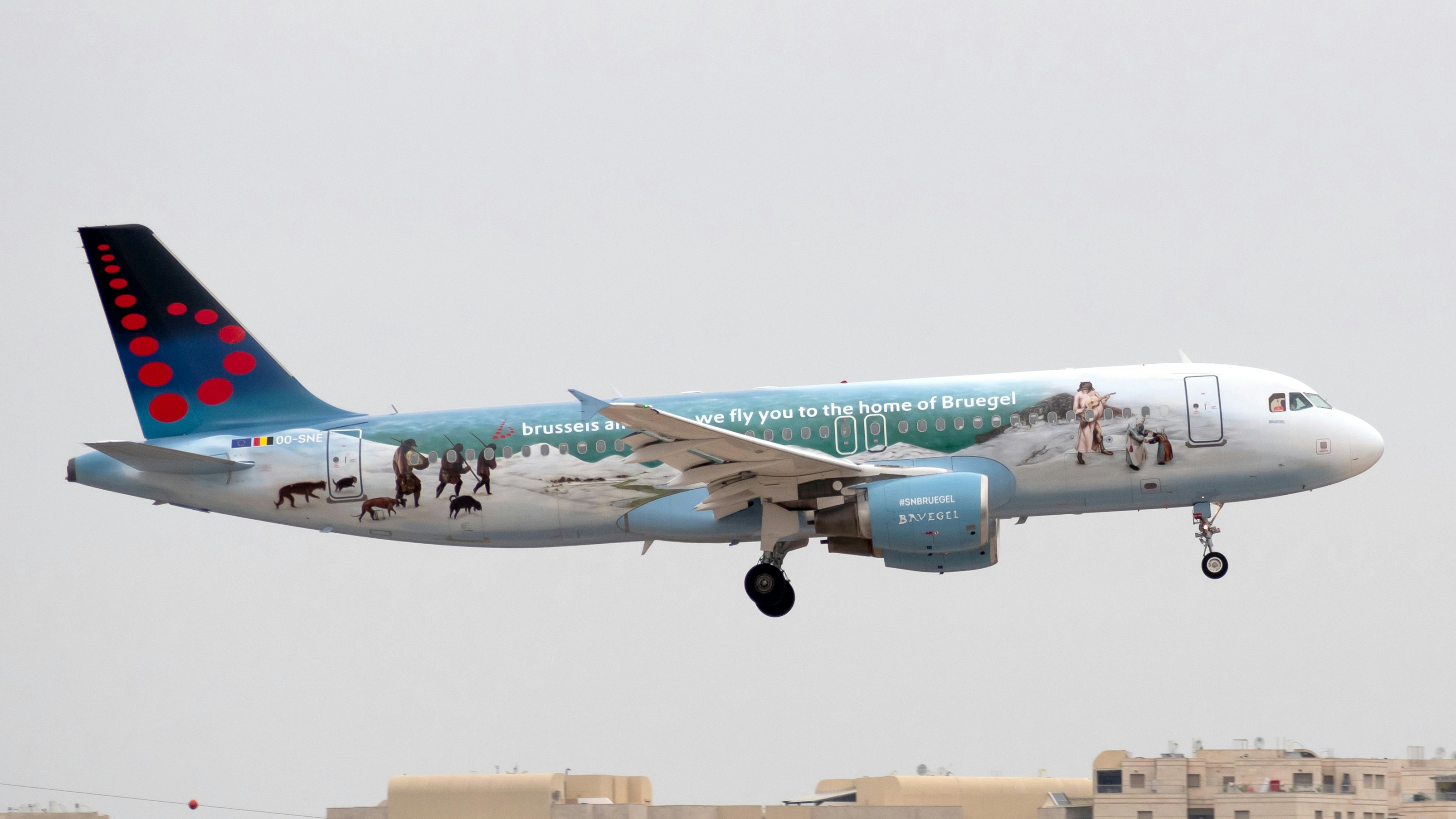 white and blue air plane in mid air during daytime, Brussels Airlines Airbus 320, painted with the Bruegel Livery. Taken at Ben Gurion airport.