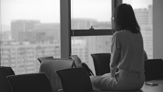 woman in white coat sitting on black chair