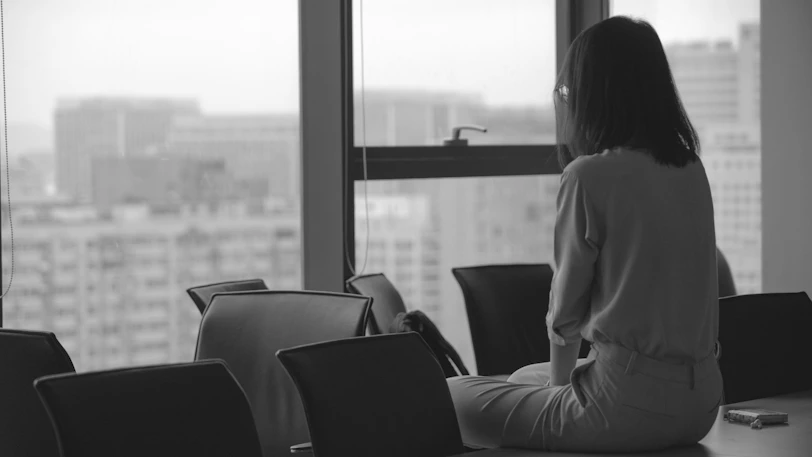 woman in white coat sitting on black chair