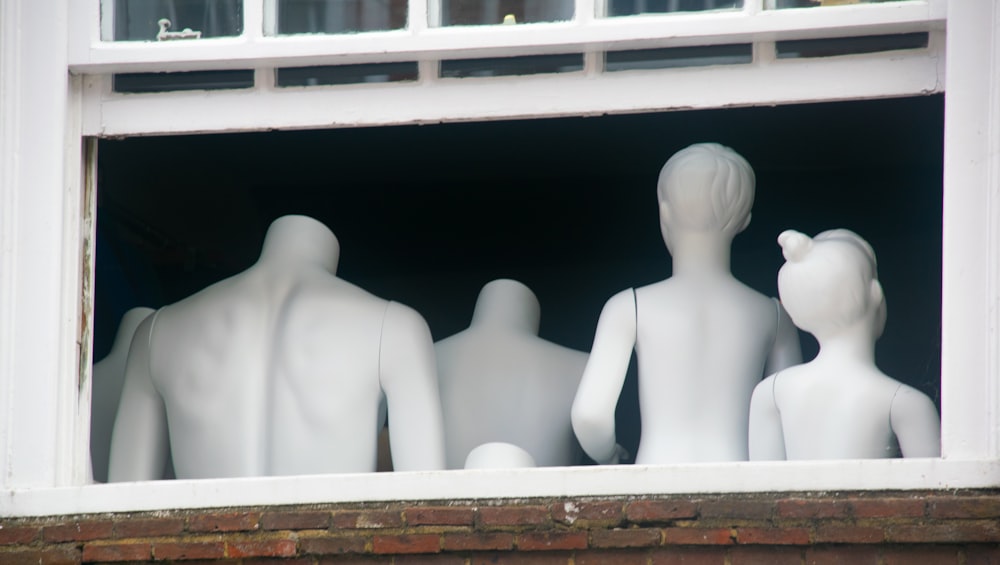 white ceramic figurines on white wooden window frame