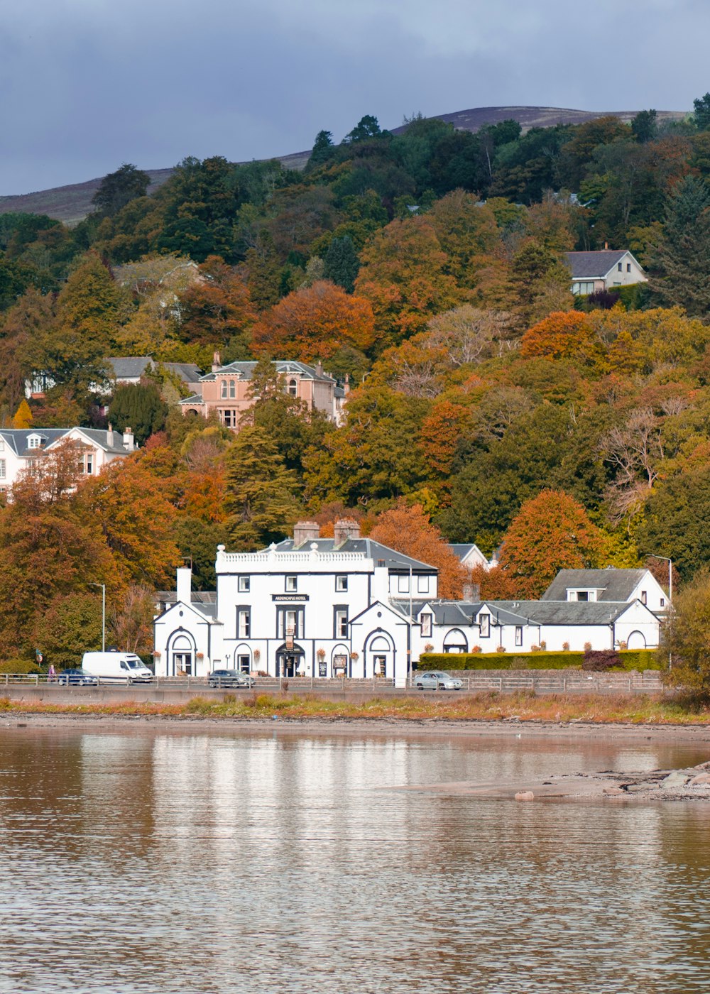 white and brown house near body of water during daytime