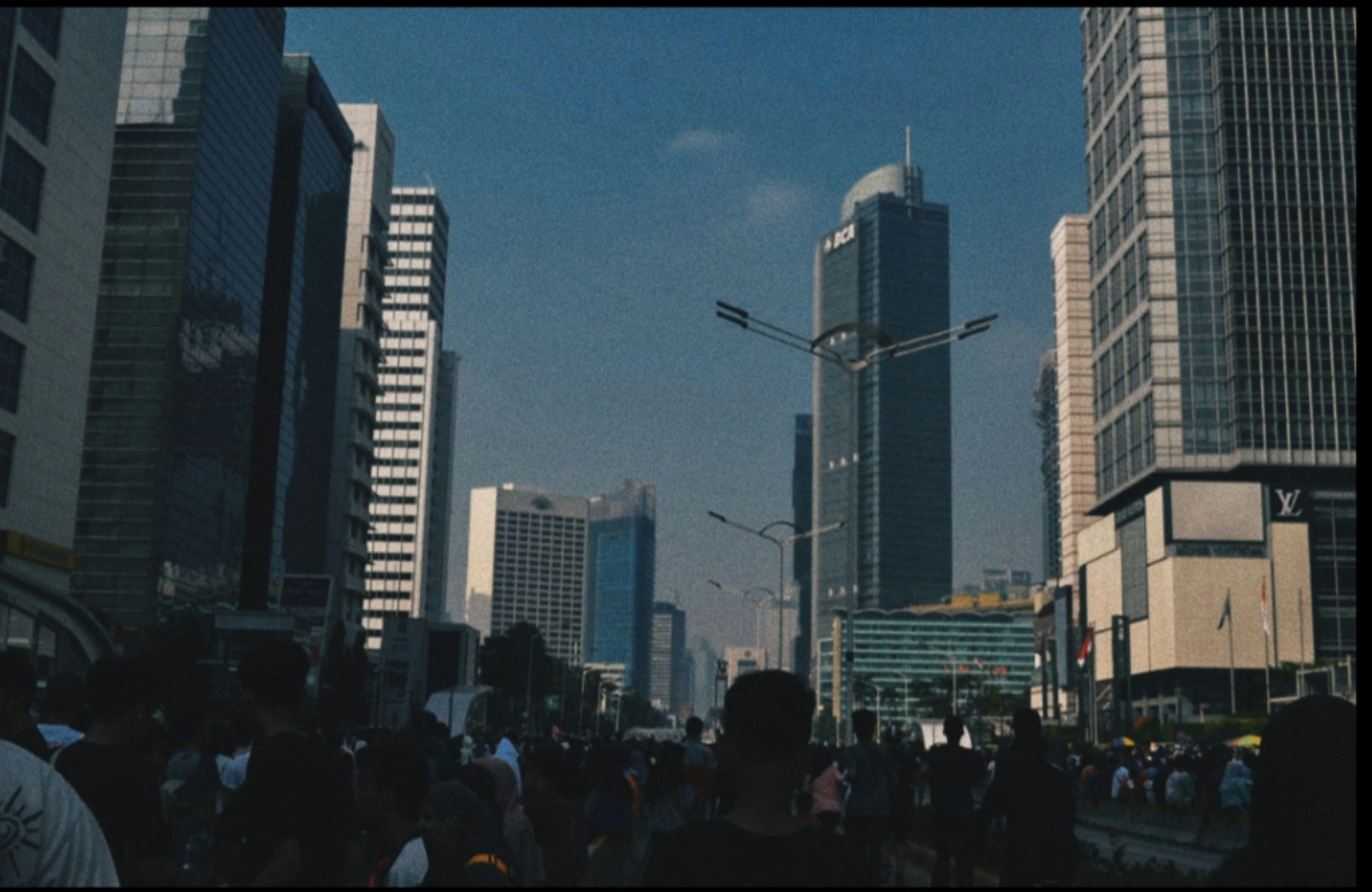 orang berjalan di jalan pada siang hari