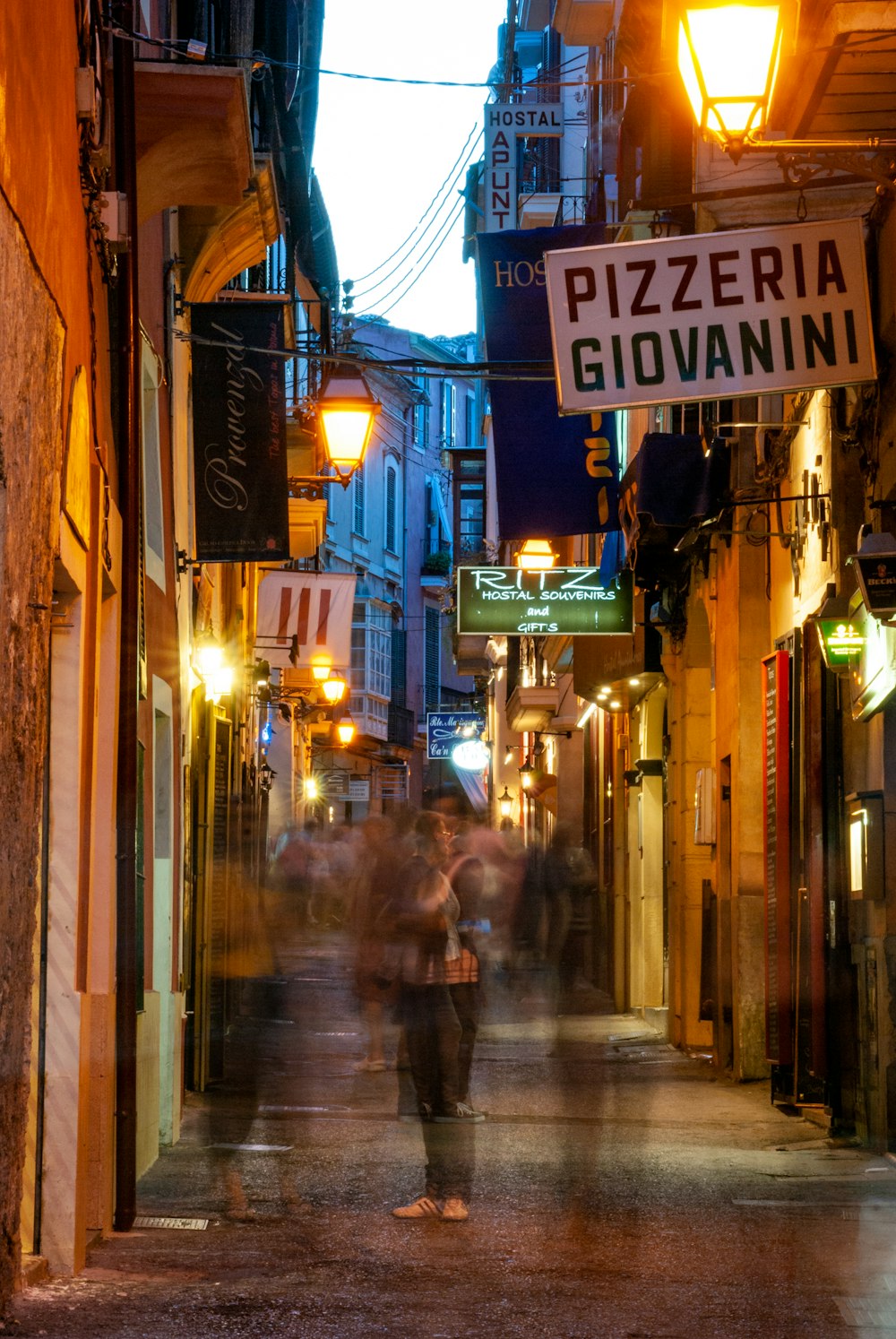 people walking on sidewalk during night time