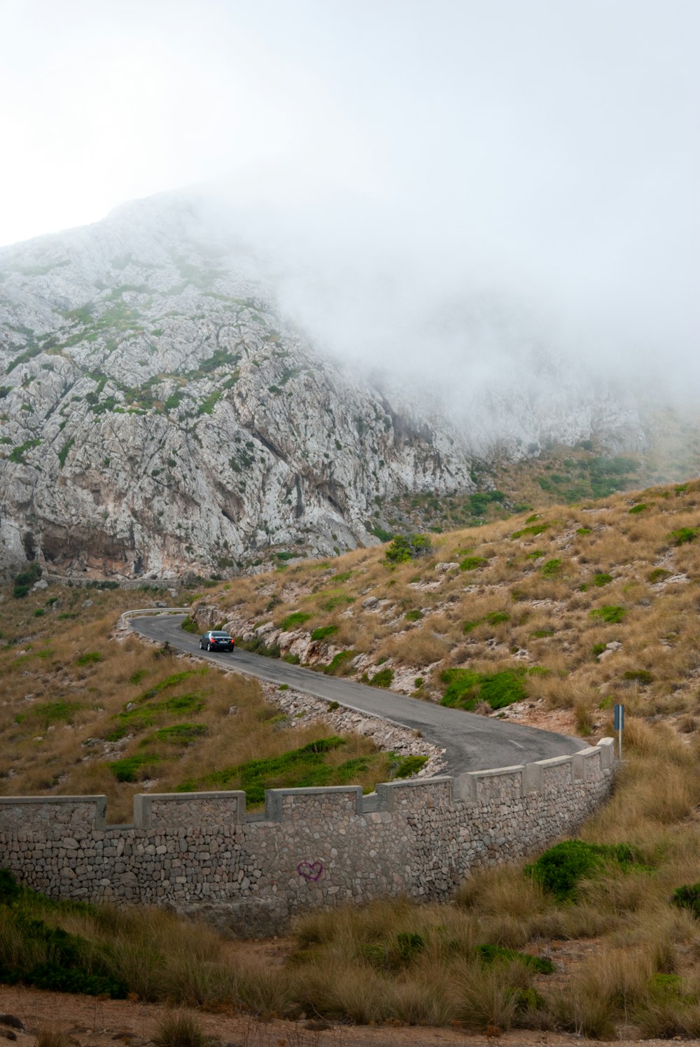 white car on road near mountain during daytime