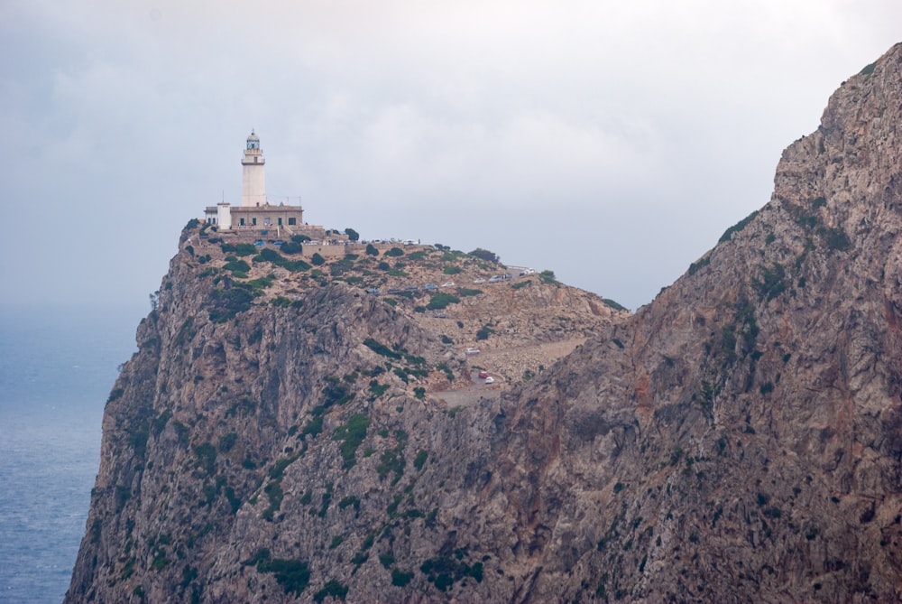 Edificio de hormigón blanco en Brown Rocky Mountain bajo un cielo blanco durante el día