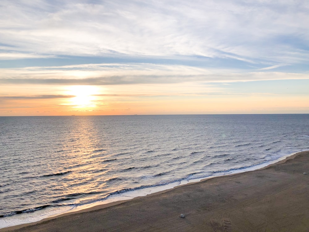 sea waves crashing on shore during sunset