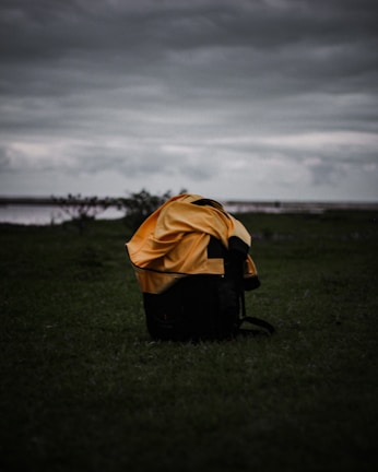 Backpack resting on a wooden bench with raindrops highlighting its water resistance.
