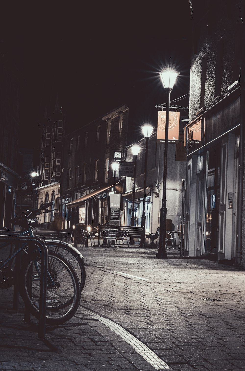 black bicycle parked beside building during night time