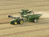 green and yellow tractor on brown field during daytime