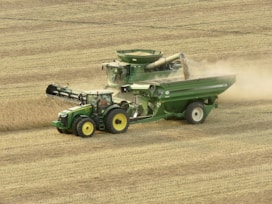 green and yellow tractor on brown field during daytime
