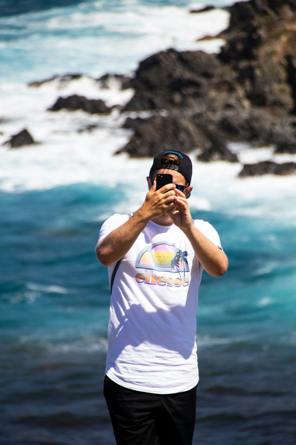 man in white crew neck t-shirt wearing black cap