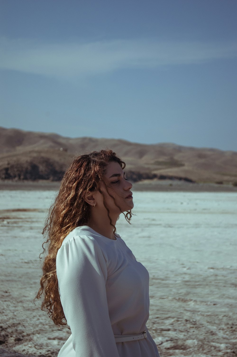 woman in white shirt standing near body of water during daytime