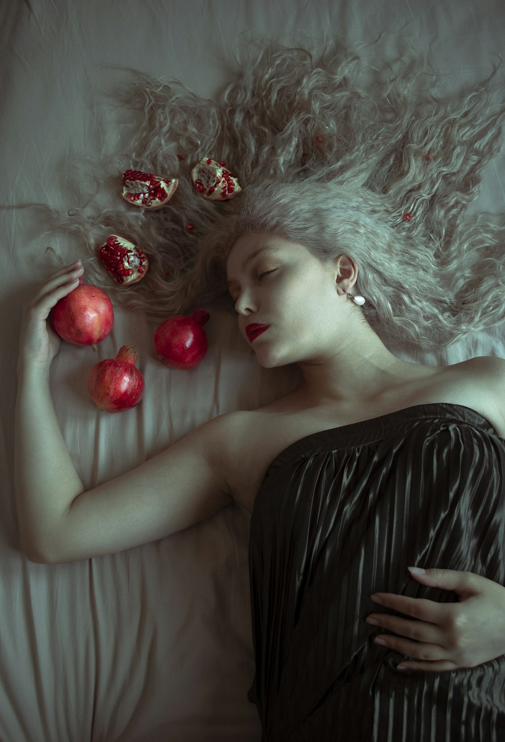 woman in black dress lying on white textile