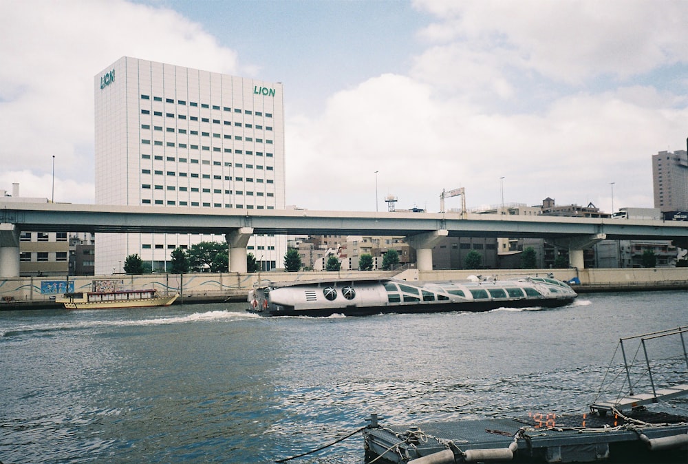 white and black boat on body of water near white concrete building during daytime